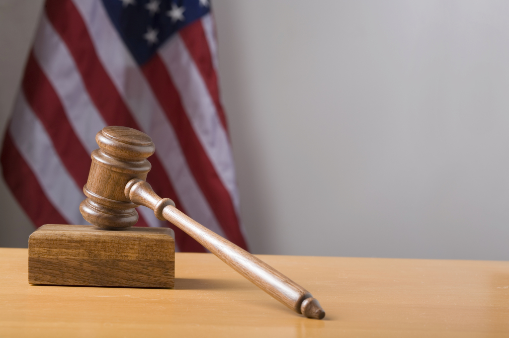 Gavel and US Flag in the background. Selective focus on the gavel.